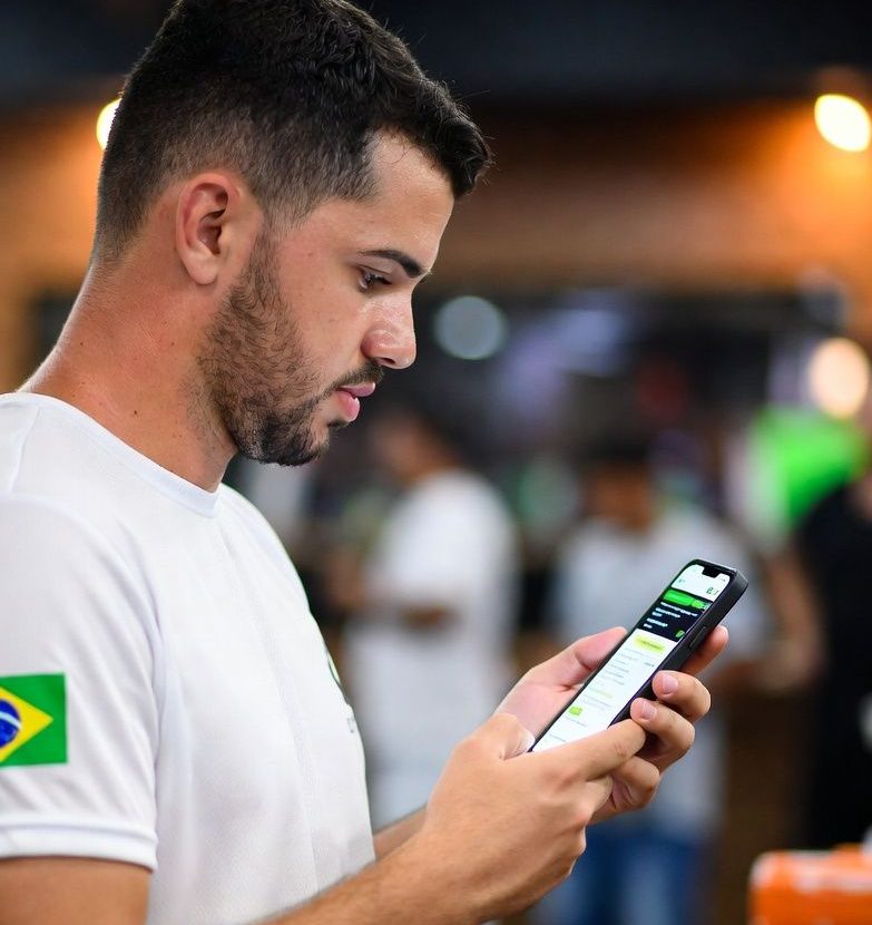 Brazilian sports bettor reviewing bonus terms on a smartphone